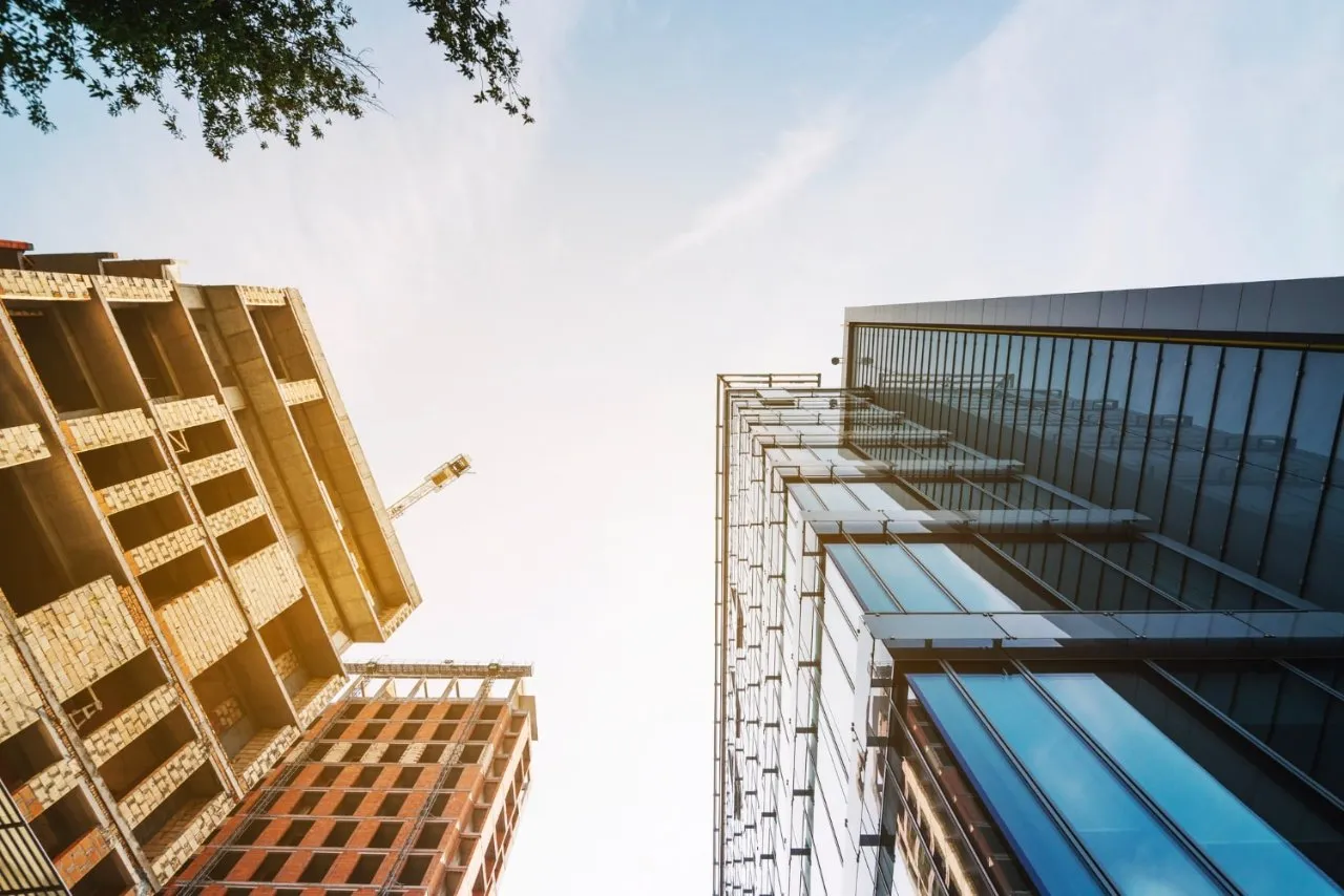 Two towering buildings captured from a low angle, showcasing their impressive height and architectural grandeur.