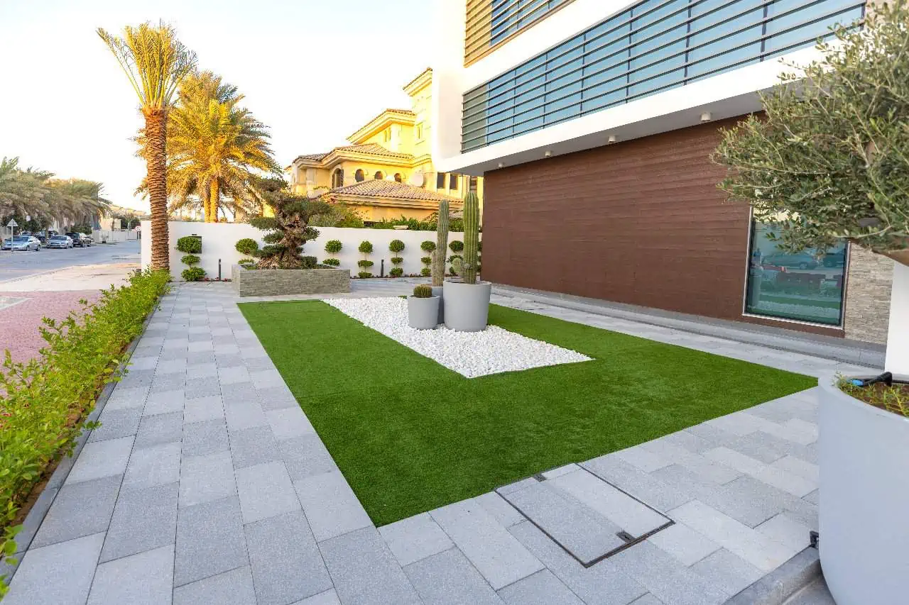 A contemporary home with synthetic turf and a decorative planter.