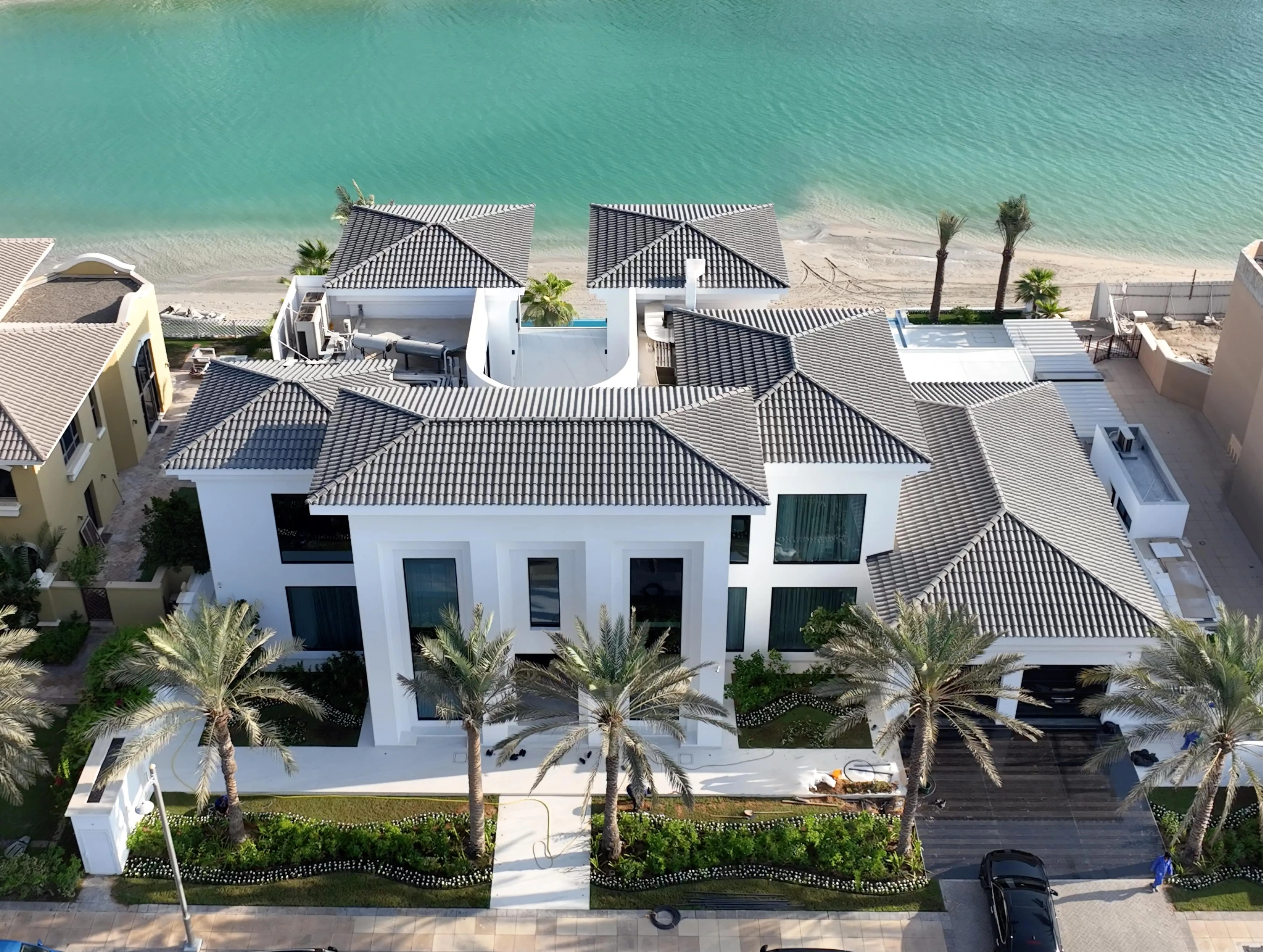 A stunning white house with a pool and palm trees, offering a serene and luxurious living space.