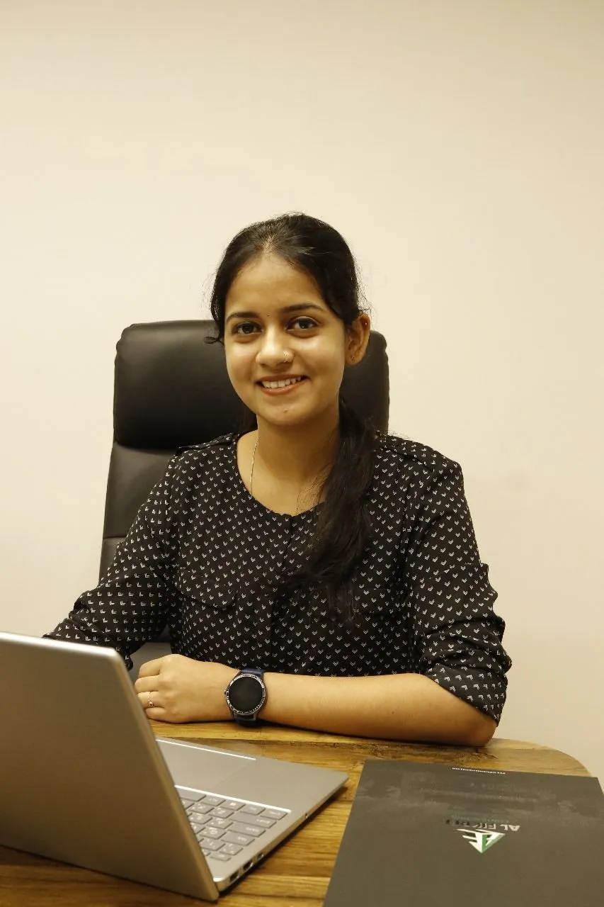 A woman engaged with her laptop at a desk, creating a warm and inviting atmosphere in her workspace.