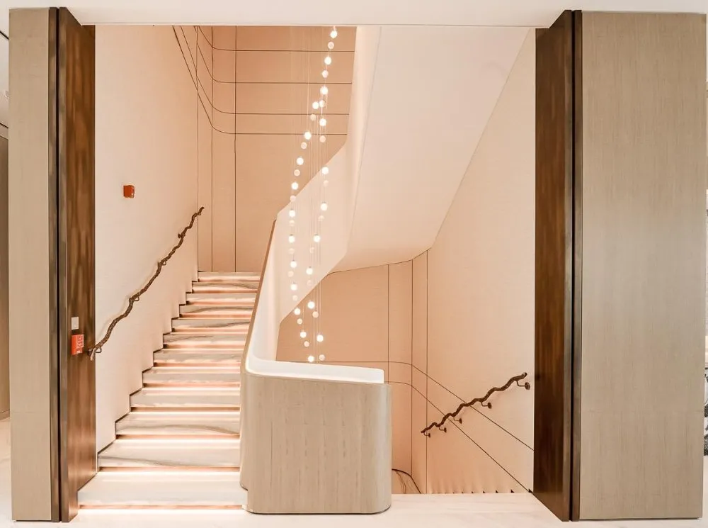 A modern staircase with illuminated steps and a minimalist design, featuring soft lighting and sleek wooden accents.