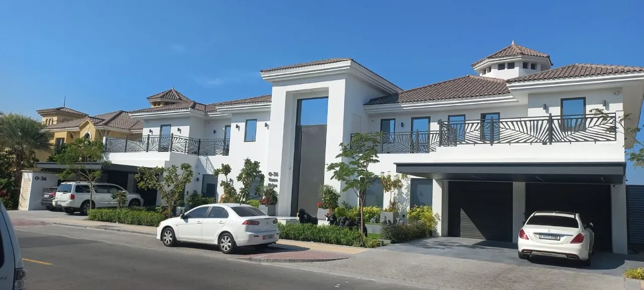 A beautiful white house with parked cars in front, creating a serene and inviting atmosphere.