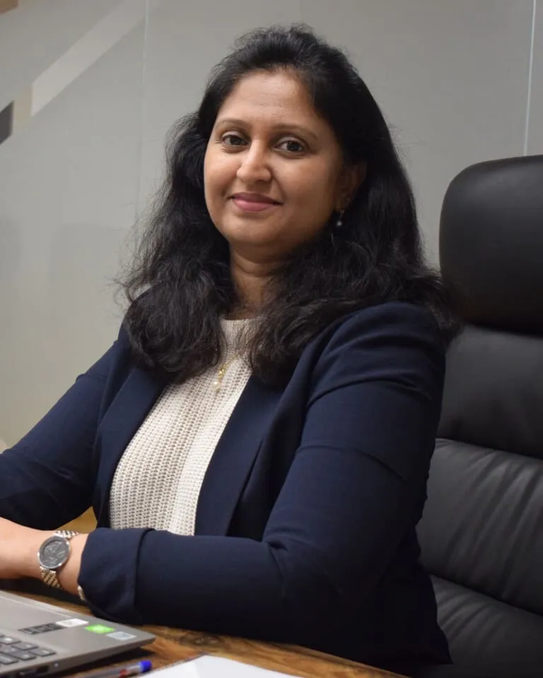 A businesswoman sitting at a desk, focused and professional.