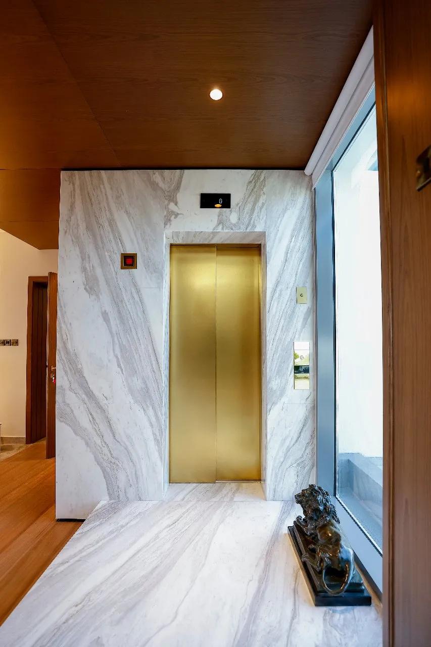 A luxurious home with a marble floor and a gleaming gold elevator, adding elegance to the modern interior.