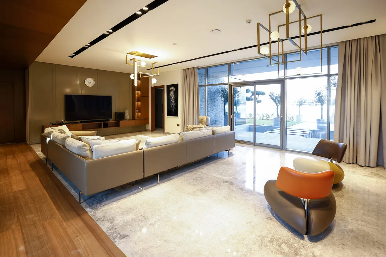 A modern living room with a large glass wall, offering a stunning view of the outside world.