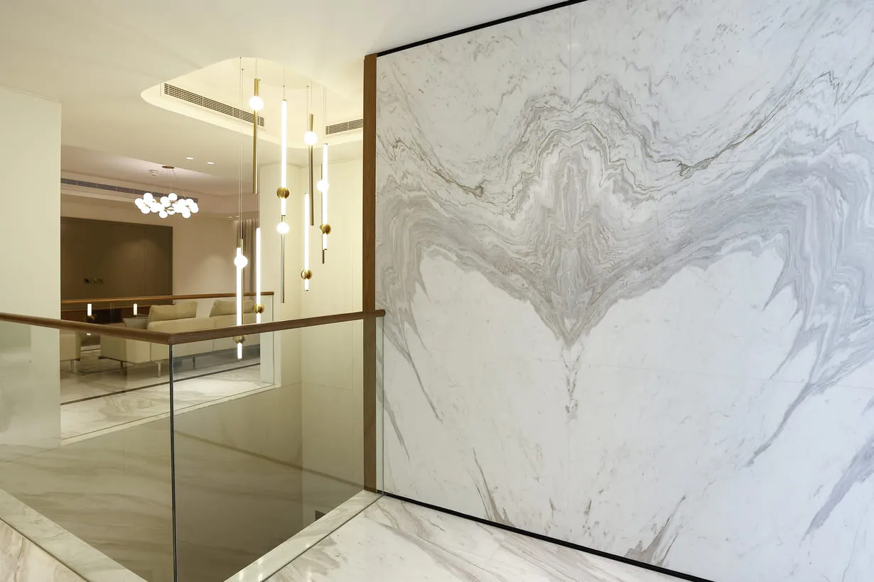 A modern home with a marble wall and glass railing, creating a sleek and sophisticated ambiance.