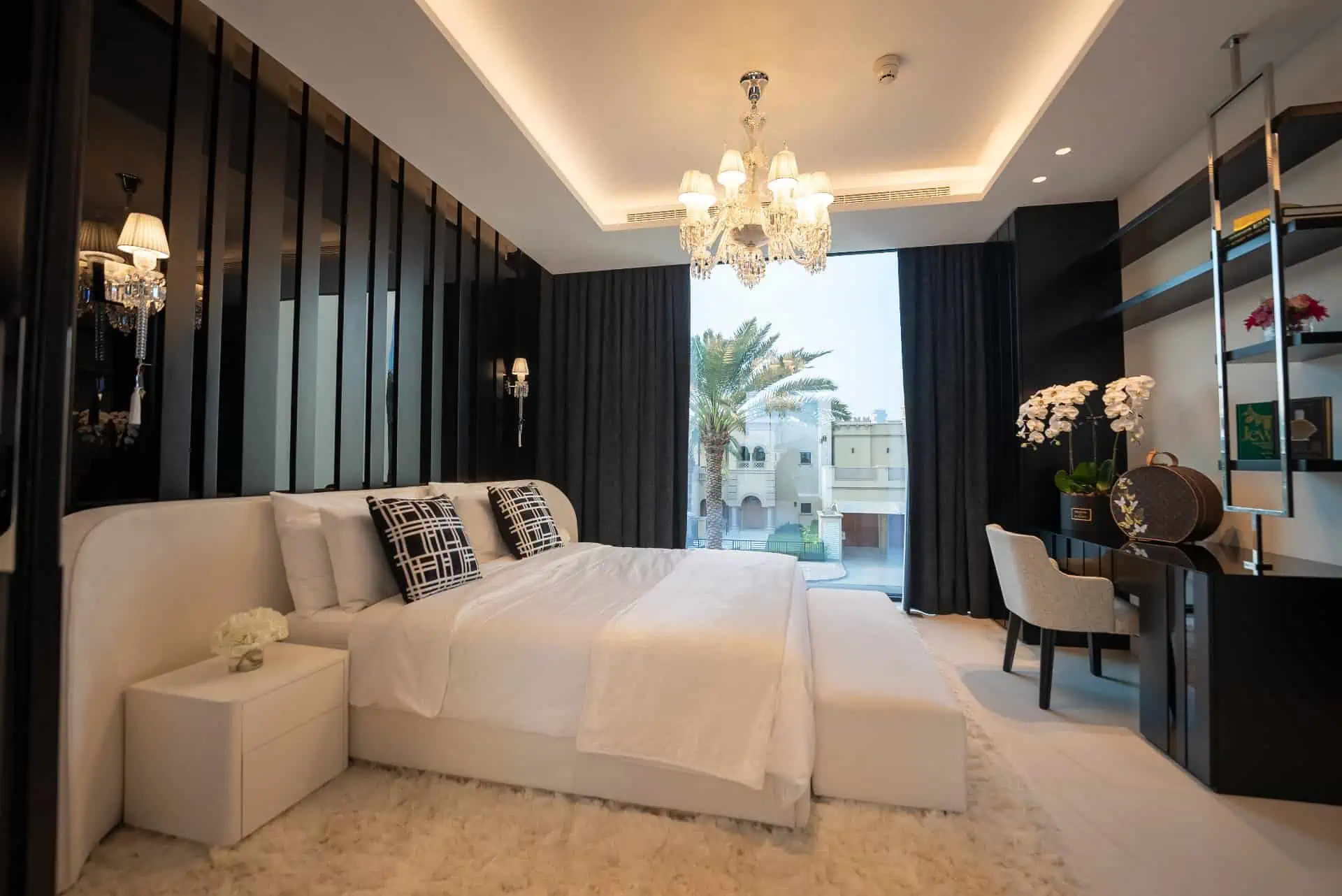 a bedroom with a large bed and a chandelier